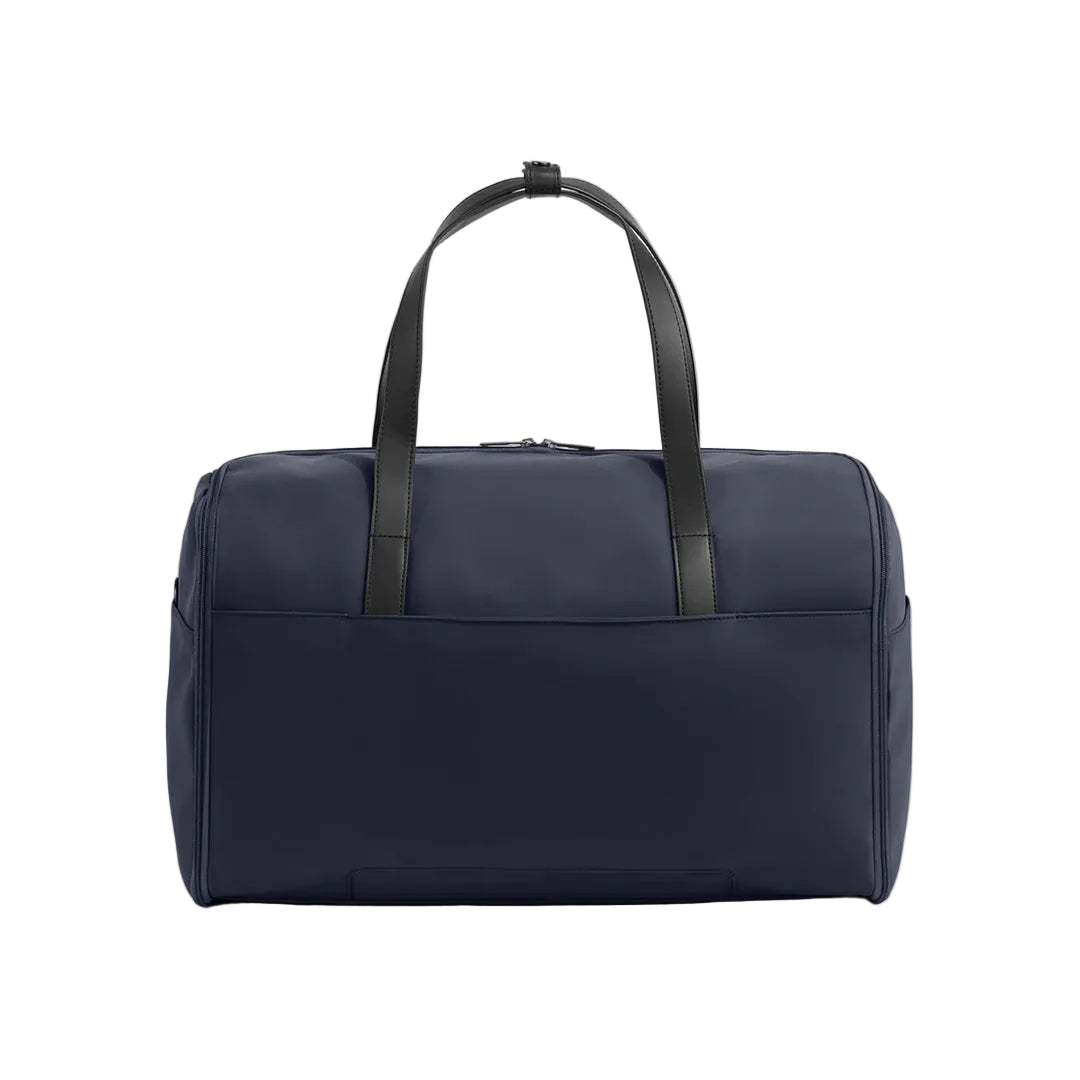 A navy blue duffel bag with black leather handles, shown from the front against a light gray studio background.